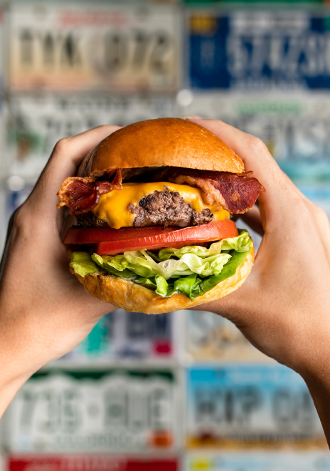 Person holding cheeseburger